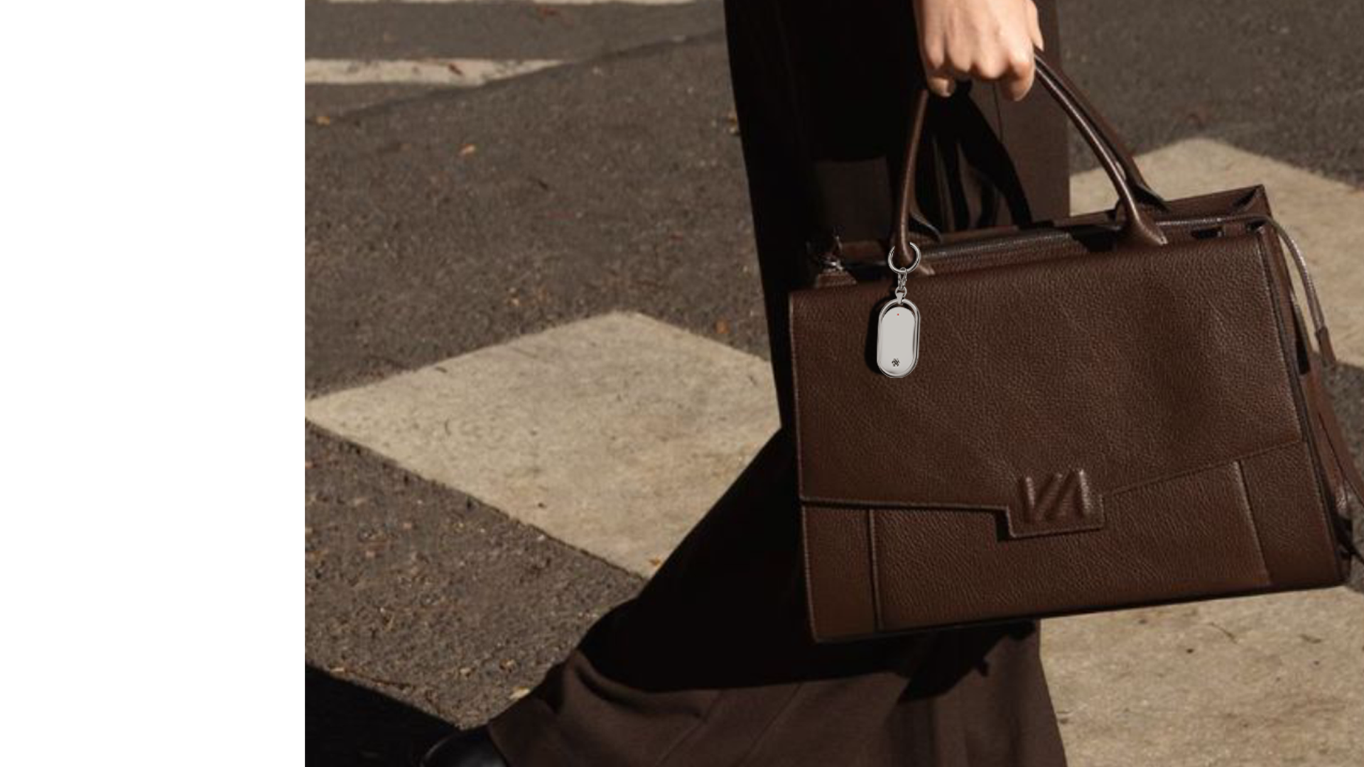 NUVA carried as a charm on a brown handbag.